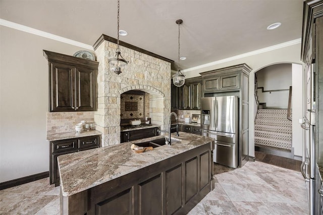 15101 Colonia Bella Dr, Edmond, OK 73013 - kitchen featuring stainless steel fridge with ice dispenser, a sink, arched walkways, crown molding, and baseboards