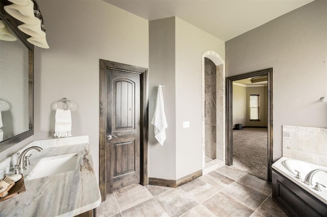 15101 Colonia Bella Dr, Edmond, OK 73013 - bathroom with vanity, tiled shower, a garden tub, and baseboards