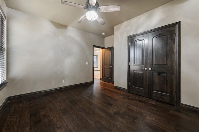 15101 Colonia Bella Dr, Edmond, OK 73013 - unfurnished bedroom featuring dark wood-type flooring, baseboards, a closet, and ceiling fan