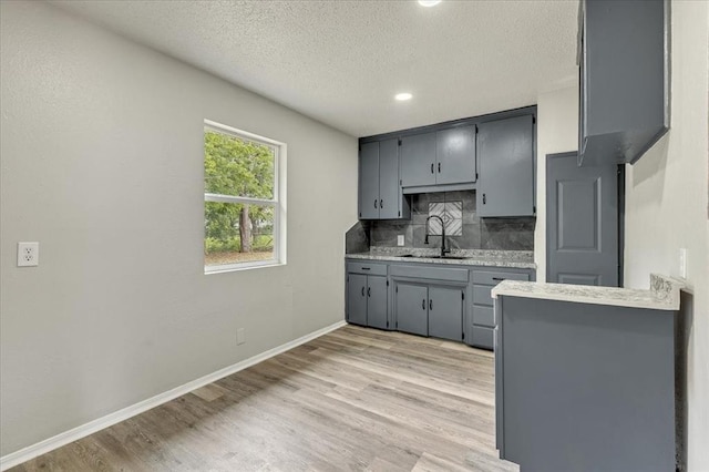 1013 Locust Ln, Midwest City, OK 73110 - kitchen with a sink, backsplash, gray cabinetry, a textured ceiling, and light countertops