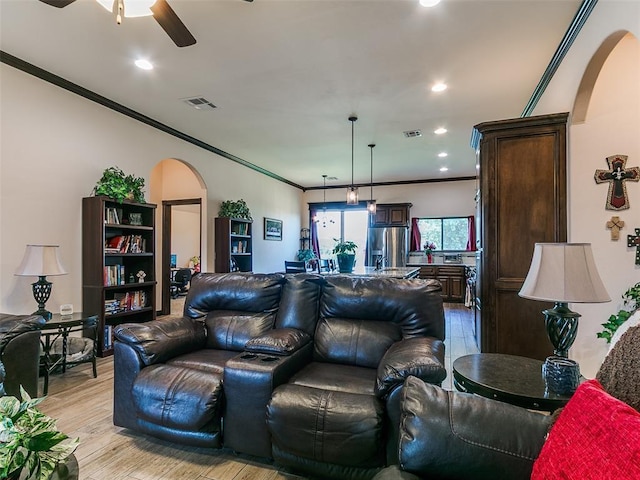 3424 Lakeside Dr, Moore, OK 73160 - living room featuring arched walkways, crown molding, a ceiling fan, light wood finished floors, and recessed lighting