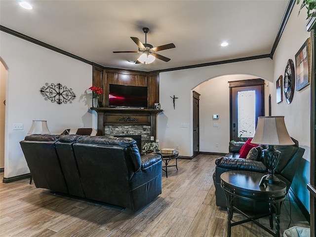 3424 Lakeside Dr, Moore, OK 73160 - living area featuring arched walkways, ornamental molding, ceiling fan, a stone fireplace, and wood finished floors