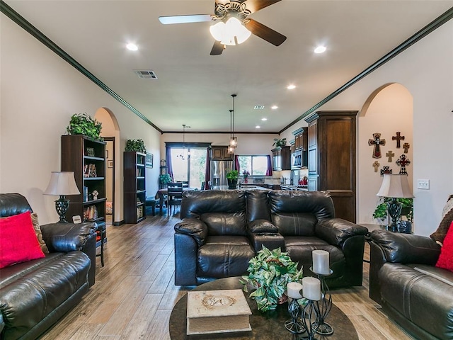 3424 Lakeside Dr, Moore, OK 73160 - living room featuring arched walkways, crown molding, light wood finished floors, ceiling fan, and recessed lighting