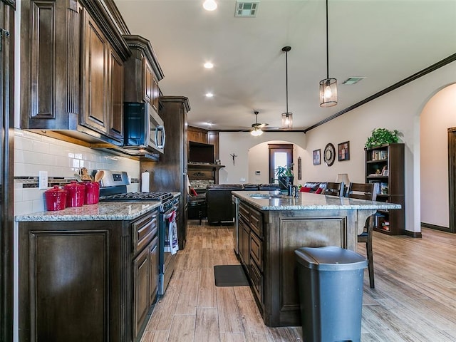 3424 Lakeside Dr, Moore, OK 73160 - kitchen featuring arched walkways, stainless steel appliances, a sink, ceiling fan, and ornamental molding
