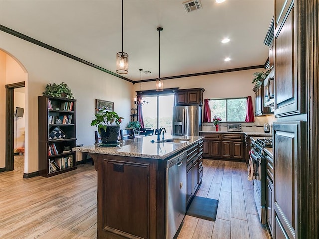 3424 Lakeside Dr, Moore, OK 73160 - kitchen with stainless steel appliances, a sink, arched walkways, dark brown cabinets, and ornamental molding