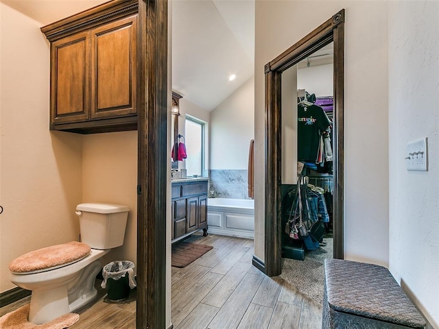 3424 Lakeside Dr, Moore, OK 73160 - full bathroom with a bath, wood finished floors, toilet, a spacious closet, and vaulted ceiling