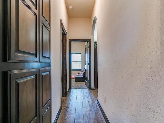 3424 Lakeside Dr, Moore, OK 73160 - hall featuring a textured wall, wood finished floors, baseboards, and arched walkways