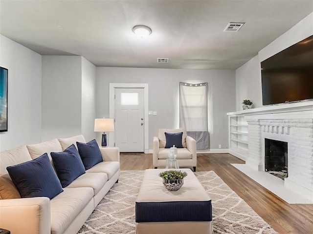 1017 N Broadway Ave, Shawnee, OK 74801 - living room with wood finished floors, a brick fireplace, and baseboards