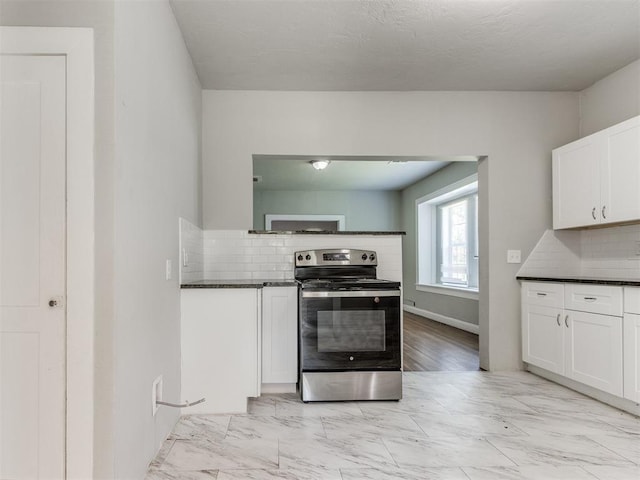 1017 N Broadway Ave, Shawnee, OK 74801 - kitchen with stainless steel electric range oven, dark countertops, decorative backsplash, and white cabinetry