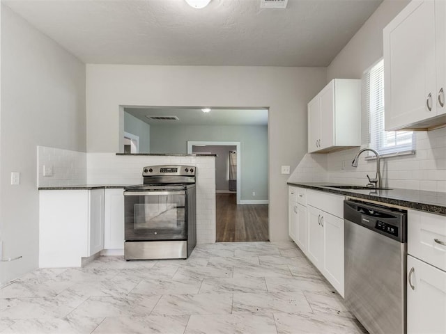 1017 N Broadway Ave, Shawnee, OK 74801 - kitchen with appliances with stainless steel finishes, a sink, backsplash, and white cabinets