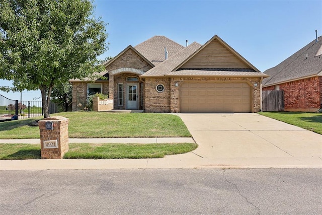 4921 SW 120th Ter, Oklahoma City, OK 73173 - view of front of property with a garage, driveway, brick siding, and roof with shingles