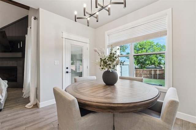 124 W 5th St, Arcadia, OK 73007 - dining space with light wood finished floors, a chandelier, and a fireplace