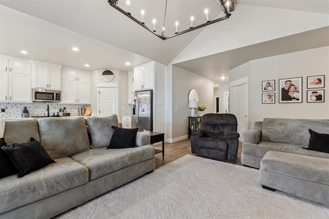 124 W 5th St, Arcadia, OK 73007 - living room with light wood-type flooring, recessed lighting, high vaulted ceiling, and a chandelier