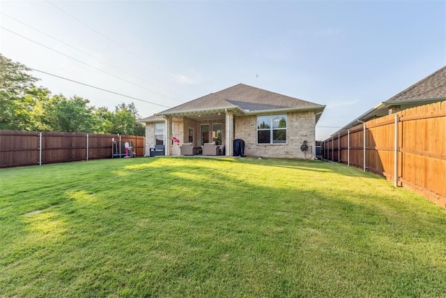 124 W 5th St, Arcadia, OK 73007 - rear view of house featuring a fenced backyard, brick siding, and roof with shingles
