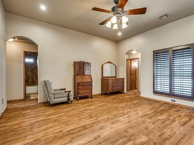 3501 Shell Ln, Yukon, OK 73099 - unfurnished room with arched walkways, a ceiling fan, light wood-style flooring, baseboards, and plenty of natural light