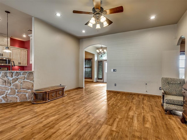 3501 Shell Ln, Yukon, OK 73099 - living room featuring arched walkways, light wood finished floors, ceiling fan, recessed lighting, and baseboards