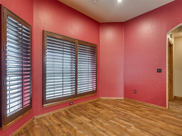 3501 Shell Ln, Yukon, OK 73099 - spare room with wood finished floors, arched walkways, and a textured wall