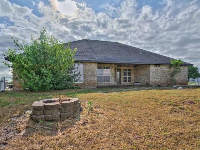 3501 Shell Ln, Yukon, OK 73099 - rear view of property with a fire pit, brick siding, a yard, and roof with shingles