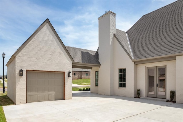 2917 Kite Tail Xing, Edmond, OK 73034 - exterior space featuring concrete driveway, a chimney, brick siding, roof with shingles, and a garage
