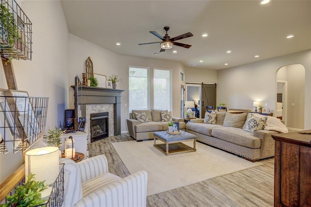 2613 Ethan Ln, Oklahoma City, OK 73160 - living area featuring arched walkways, wood finished floors, ceiling fan, a stone fireplace, and recessed lighting