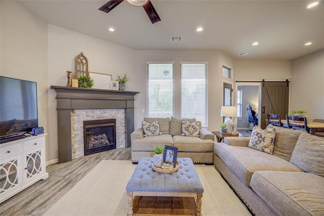 2613 Ethan Ln, Oklahoma City, OK 73160 - living room with ceiling fan, recessed lighting, wood finished floors, a barn door, and a stone fireplace