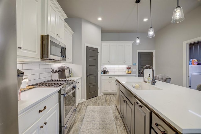 2613 Ethan Ln, Oklahoma City, OK 73160 - kitchen with stainless steel appliances, a sink, light wood finished floors, light countertops, and white cabinets
