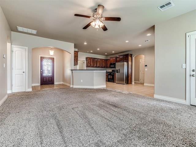 1861 Debbie Dr, Guthrie, OK 73044 - unfurnished living room featuring arched walkways, a ceiling fan, light carpet, recessed lighting, and light tile patterned flooring