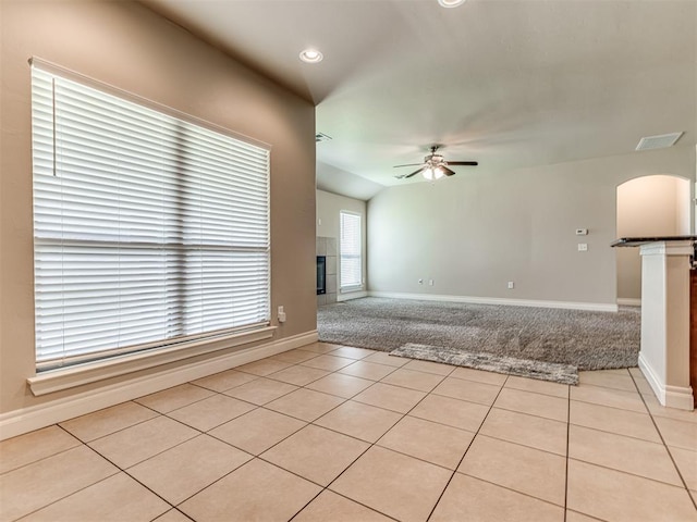 1861 Debbie Dr, Guthrie, OK 73044 - spare room with ceiling fan, arched walkways, a fireplace, light tile patterned flooring, and baseboards