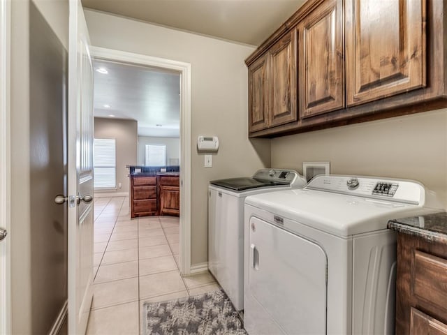 1861 Debbie Dr, Guthrie, OK 73044 - laundry area featuring washing machine and dryer, cabinet space, light tile patterned floors, and baseboards
