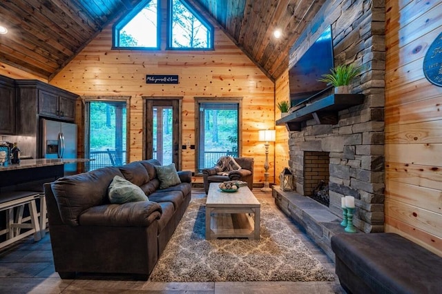 193 Pine Forest Trl, Broken Bow, OK 74728 - living room with high vaulted ceiling, wooden walls, wood ceiling, a fireplace, and wood finished floors