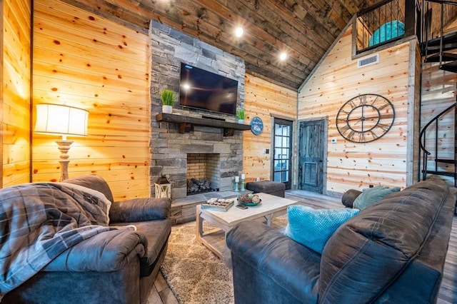 193 Pine Forest Trl, Broken Bow, OK 74728 - living room with high vaulted ceiling, wooden walls, wood ceiling, wood finished floors, and a stone fireplace