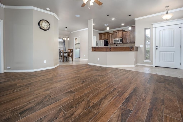 7521 Prairie Twyne Dr, Yukon, OK 73099 - unfurnished living room with dark wood-style flooring, ceiling fan, baseboards, ornamental molding, and recessed lighting
