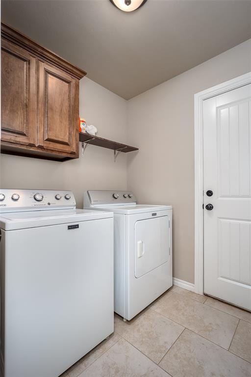 7521 Prairie Twyne Dr, Yukon, OK 73099 - laundry area featuring separate washer and dryer, cabinet space, baseboards, and light tile patterned floors