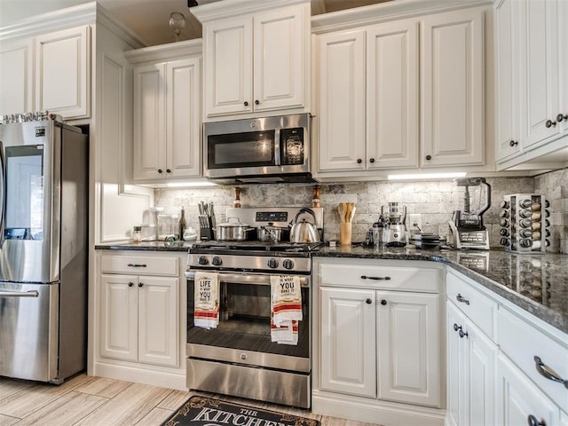 11728 SW 15th Ter, Yukon, OK 73099 - kitchen with appliances with stainless steel finishes, white cabinets, and tasteful backsplash