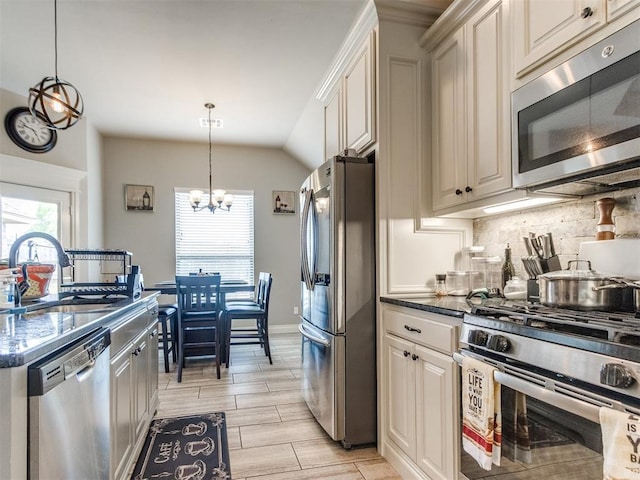 11728 SW 15th Ter, Yukon, OK 73099 - kitchen with appliances with stainless steel finishes, a sink, decorative backsplash, a chandelier, and decorative light fixtures