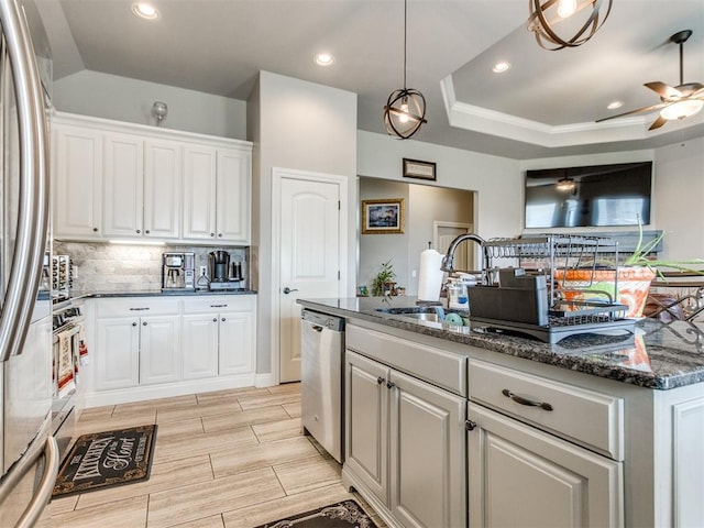 11728 SW 15th Ter, Yukon, OK 73099 - kitchen featuring appliances with stainless steel finishes, white cabinets, decorative backsplash, ceiling fan, and dark stone countertops