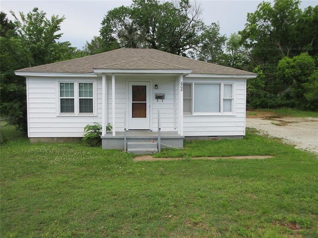 608 W Walnut St, Tecumseh, OK 74873 - bungalow-style home featuring a front yard, roof with shingles, and covered porch