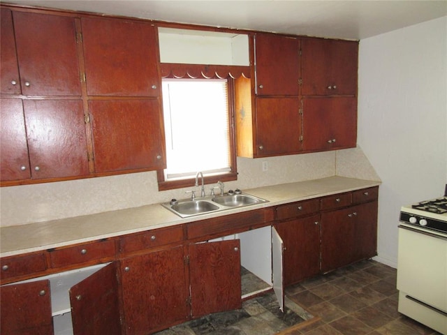 608 W Walnut St, Tecumseh, OK 74873 - kitchen featuring white gas range, a sink, light countertops, and stone finish floors