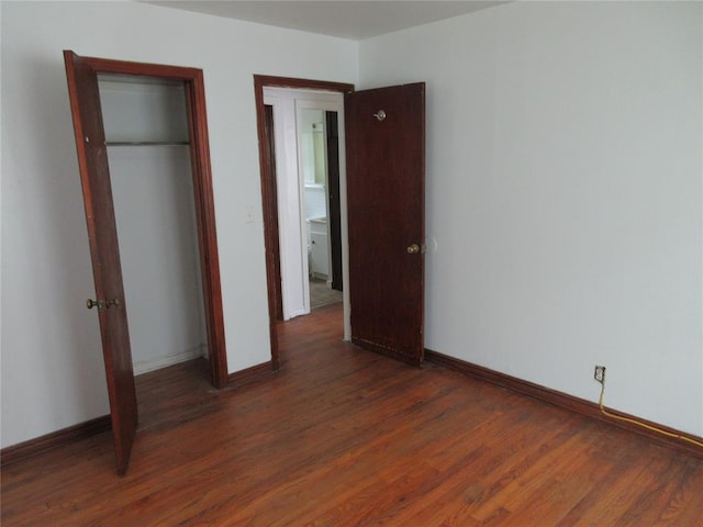 608 W Walnut St, Tecumseh, OK 74873 - unfurnished bedroom featuring wood finished floors, baseboards, and a closet