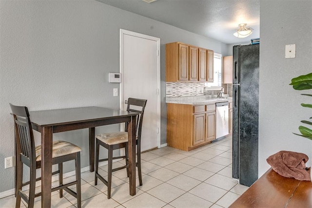 1705 NW 147th St, Edmond, OK 73013 - kitchen featuring freestanding refrigerator, stainless steel dishwasher, light countertops, light tile patterned floors, and backsplash
