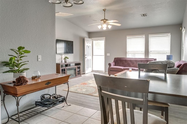 1705 NW 147th St, Edmond, OK 73013 - dining area featuring a textured wall, ceiling fan, lofted ceiling, a textured ceiling, and light wood-type flooring