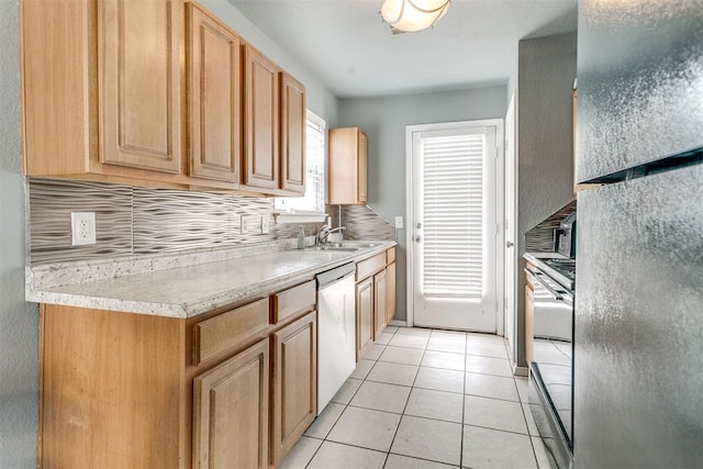 1705 NW 147th St, Edmond, OK 73013 - kitchen with stainless steel dishwasher, a sink, light countertops, light tile patterned flooring, and freestanding refrigerator