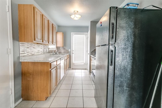 1705 NW 147th St, Edmond, OK 73013 - kitchen with freestanding refrigerator, light tile patterned flooring, light countertops, backsplash, and a sink