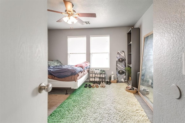 1705 NW 147th St, Edmond, OK 73013 - bedroom with wood finished floors, a ceiling fan, and a textured ceiling