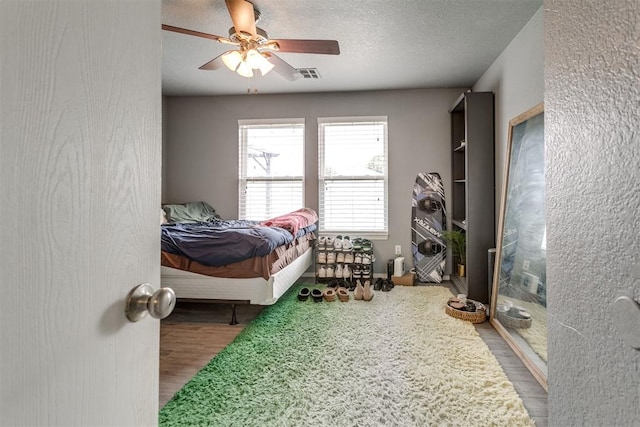 1705 NW 147th St, Edmond, OK 73013 - bedroom featuring wood finished floors, ceiling fan, and a textured ceiling
