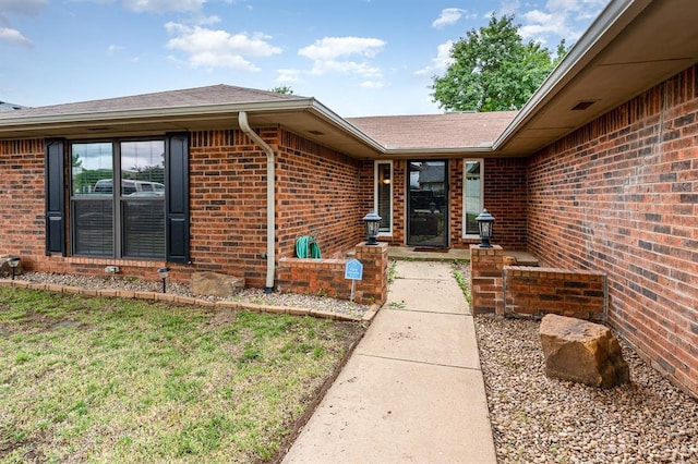 2232 Butternut Pl, Edmond, OK 73013 - entrance to property featuring brick siding, a shingled roof, and a yard