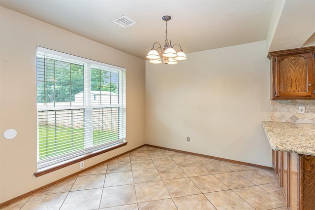 2232 Butternut Pl, Edmond, OK 73013 - unfurnished dining area with a chandelier, baseboards, and light tile patterned floors