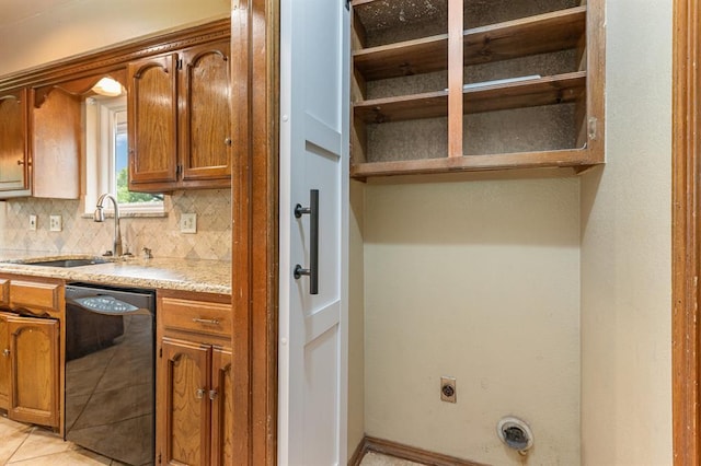 2232 Butternut Pl, Edmond, OK 73013 - kitchen featuring black dishwasher, a sink, tasteful backsplash, brown cabinetry, and light tile patterned flooring