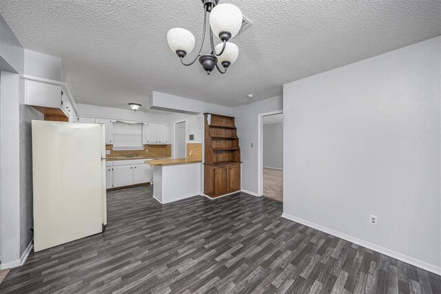 7506 NW Welco Ave, Lawton, OK 73505 - unfurnished living room with dark wood-style flooring, a chandelier, baseboards, and a textured ceiling