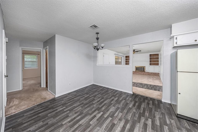 7506 NW Welco Ave, Lawton, OK 73505 - unfurnished dining area featuring dark wood finished floors, a glass covered fireplace, ceiling fan, a textured ceiling, and baseboards